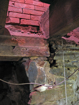 Brick wall over wood beam over stone foundation_8308