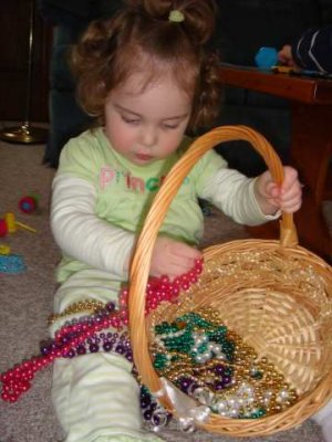playing with mardi gras beads- beads go in the basket