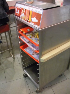 Fast food does not have trashcans. This is the trash, slide your tray in here.