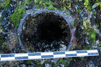 View down blow hole. Sunlight fainly visible at bottom.