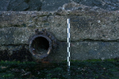 Outflow pipe and wall. Note hinge points for flapper cover