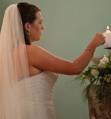 The bride lights her candle