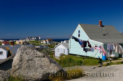 Rural fishing village houses with laundry and the lighthouse at Peggys Cove Nova Scotia