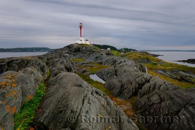Cape Forchu lighthouse peninsula with wet rocks and grass Yarmouth Harbour Nova Scotia