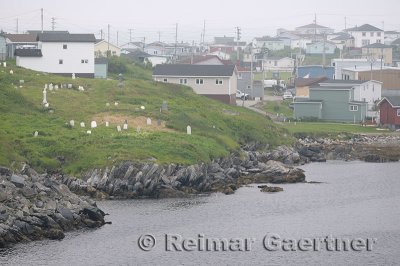 Cemetery and houses on the waterfront shores of Port aux Basques Newfoundland harbour