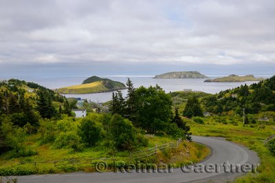 Road winding down to Tors Cove harbour with Fox Island and Great and Ship Island bird sanctuaries Newfoundland