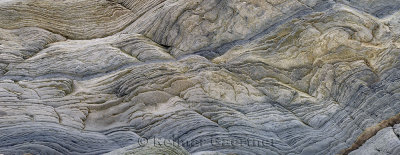 Panorama of abstract pattern of wavy sedimentary layers of stone at Bay of Fundy Cape Enrage