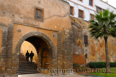 Two young men walking up the steps of the East entrance gate to the Old Medina Casablanca