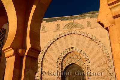 Doorway to the Hassan II Mosque Casablanca at sunset seen through stone archway
