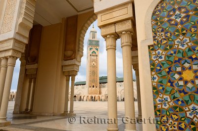 Hassan II Mosque minaret framed by a plaza arch and tilework in Casablanca Morocco