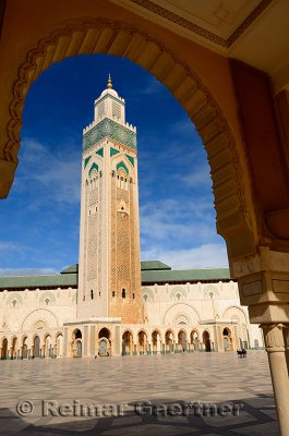 Hassan II mosque minaret framed by a plaza arch in Casablanca Morocco
