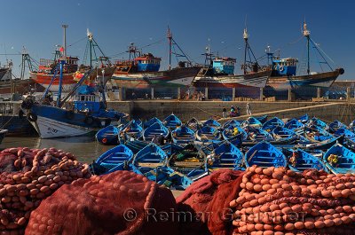 Blue fishing boats and red nets in the morning at the marine port of Essaouira Morocco