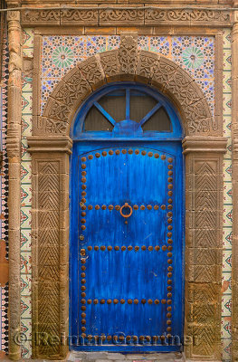 Blue door in Essaouira Medina with ornate stonework and Zellige tilework