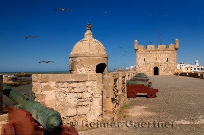 Sqala du Port fortress with cannons and Essaouira city with Sqala de la Ville and North Bastion in the distance