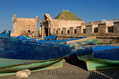 Sqala du Port and Marine Gate with blue and green fishing boats for sale in Essaouira Morocco