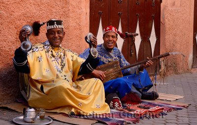 Happy Gnawa street musicians playing and singing in Marrakech with swinging tarboosh tassels 