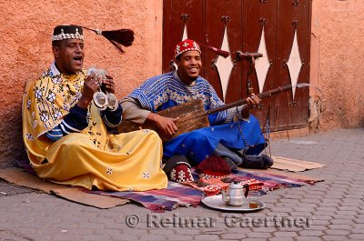 Happy Gnawa street musicians in Marrakech swinging their tarboosh tassels in time