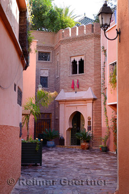 Red ochre alleyway to an upscale residence in the Souk of Marrakech Morocco