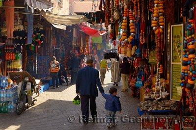 Father holding hand of son while strolling in the souk of Marrakech Morocco