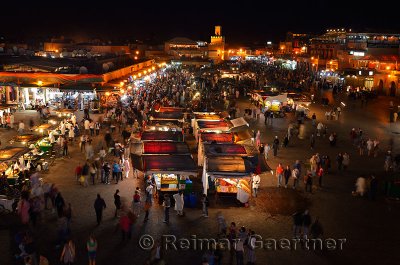 Overview of food vendors and shops at night in Place Djemaa el Fna square Marrakech Morocco