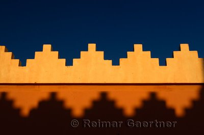 Abstract pattern of crenellations of yellow orange and blue sky Morocco