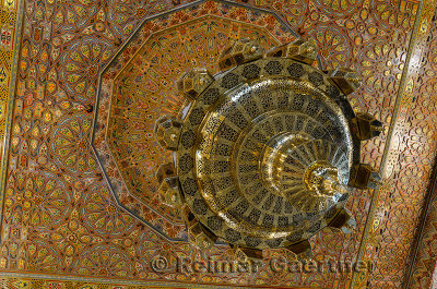 Intricately painted wood ceiling with brass chandelier in a metalware shop in Fes Morocco