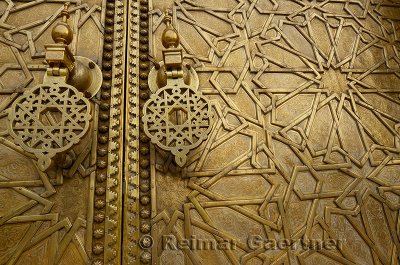 Close up of detailed engraving and knockers on the brass doors to the Dar El Makhzen palace in Fes Morocco
