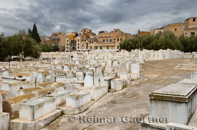 Above ground white tombs in the Mellah Jewish cemetery on a cloudy day in Fes Morocco