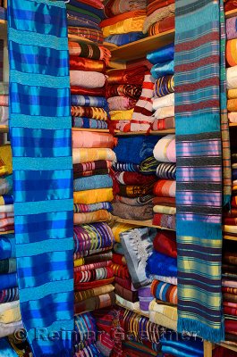 Bright colorful collection of cloth wraps in a Fes Medina Morocco textile shop