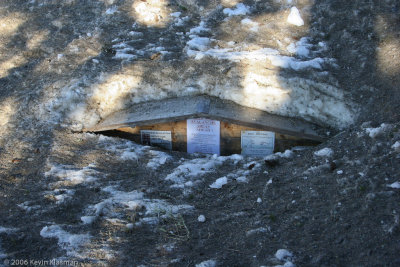 Avalanche warning on trailhead sign, almost buried by snow