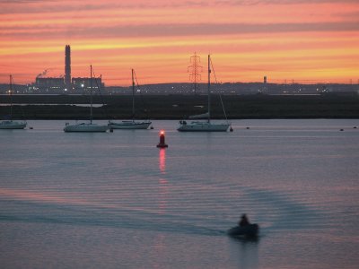 View across the Swale to Kingsnorth power station at sunset.