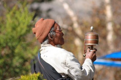 Old man turns prayers mill