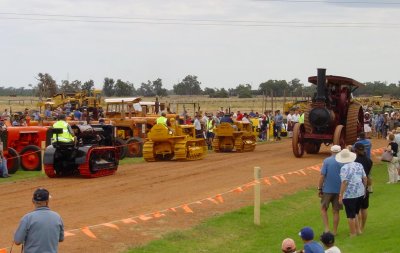 A parade of Cat crawlers - a Twenty Two, a D2, and a Best 30 - with a 1903 Marshall steam traction engine traveling the opposite direction. The wheeltractors facing the parade are all West-Australian-built Chamberlains.