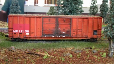 Rusty boxcar in the grass.