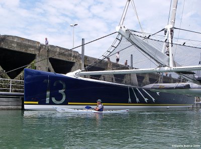 Lex paddling under a very large catamaran