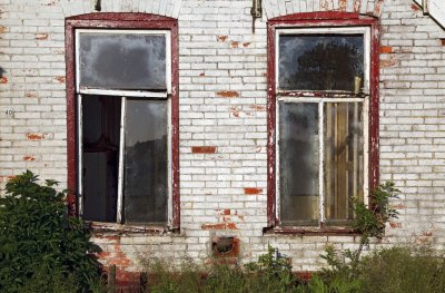 Twin windows of an abandoned farmhouse
