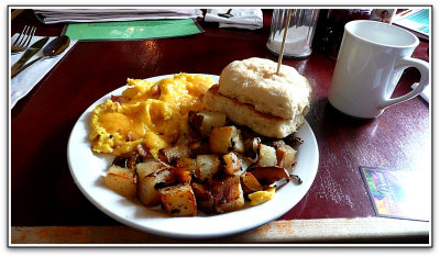  scrambled eggs with ham and cheese, potatoes and a biscuit