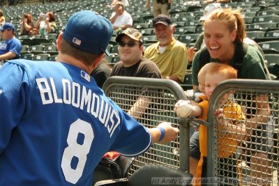 Kansas City Royals second baseman Willie Bloomquist gives a baseball to a young A's fan