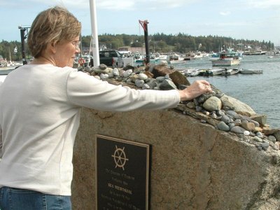 Katy places a stone at the memorial, Tremont, Maine