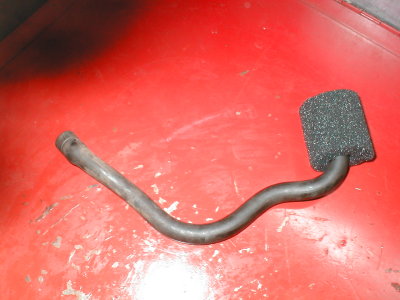 Remove hose from airbox, turn it 180 degrees and slid it down the right side of the shock and attach with hose clamp