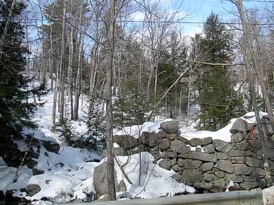 Granite dam with hill background.