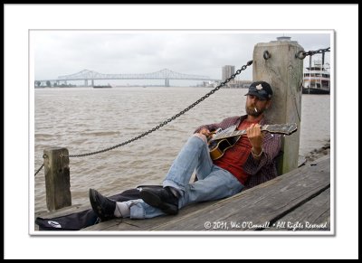 Street Musician Sitting by the Mississippi River