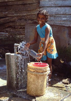 Young Girl Fetching Water from the Fresh Water Tap