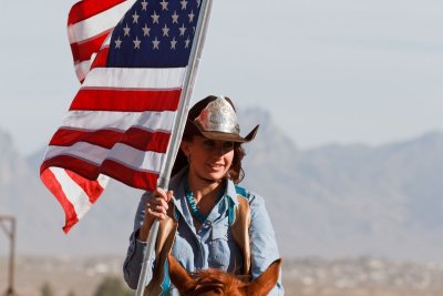 Turquoise Circuit Queen carries the flag around the arena during national anthem