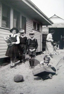 Liesbeth, Leo, Hans in school uniform, while Anneke goes down in her billycart