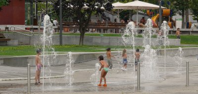 At side the children play in a fountain