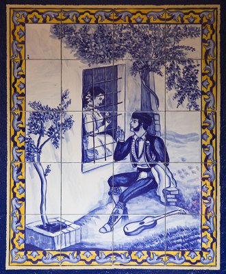 A novio 'eats iron' at the window of his novia.  (Tiled mural in bar)