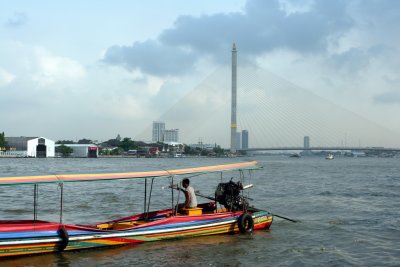 Longboat on river in front of new bridge