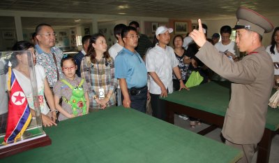 KPA officer and chinese tourists in The Armistice Talks Hall