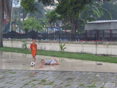 Kids playing soccer in front of a mosque in Medan